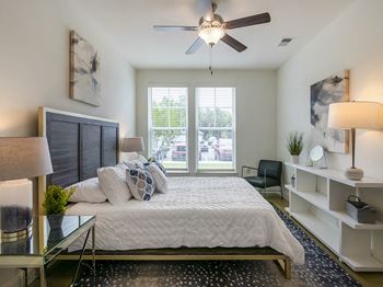 a bedroom with a large bed and a ceiling fan